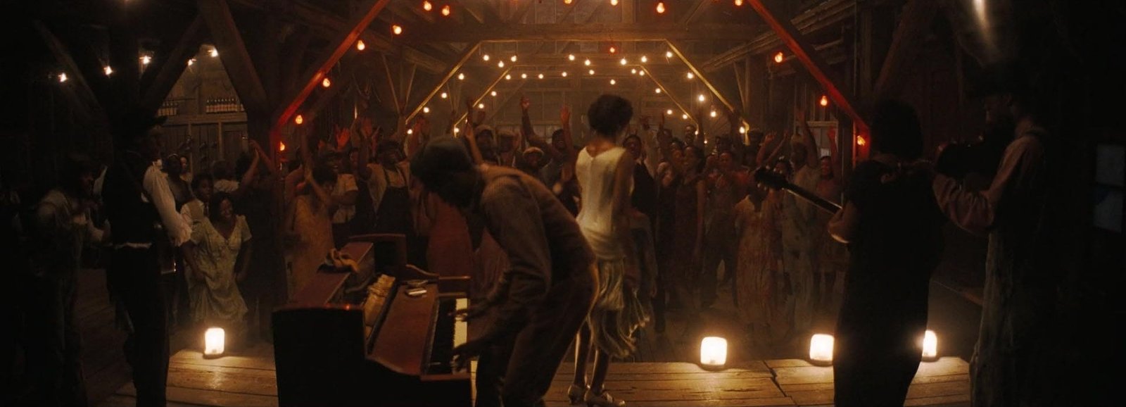 L'interno del juke joint in Sinners, con il pubblico che balla sotto le luci della segheria