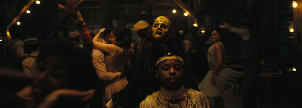 Figure mascherate e persone che ballano nella segheria in Sinners 2025